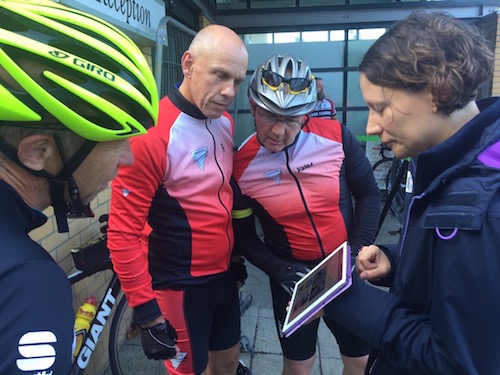 three chaps in cycling gear stand looking at the ipad I'm holding with my prototype on it.